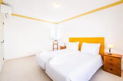a white bedroom with a large bed and two lamps at Villa Ventura Heritage in Albufeira