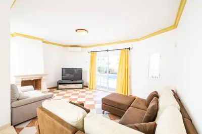 a living room with a couch and a tv at Villa Ventura Heritage in Albufeira