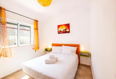 a bedroom with a white bed and a window at Milene Guest House in Albufeira