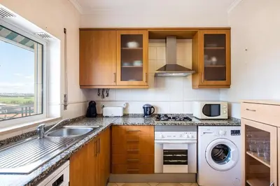 a kitchen with a sink and a washing machine at Milene Guest House in Albufeira