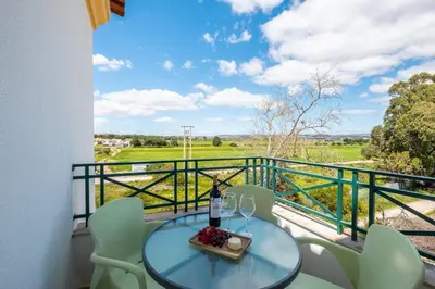 a table and chairs on a balcony with a view at Milene Guest House in Albufeira