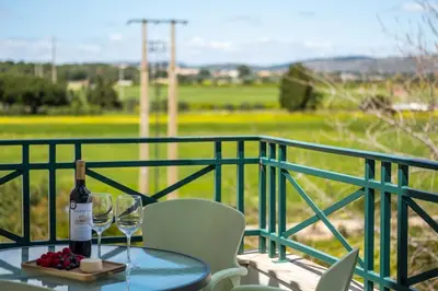 a table with a bottle of wine and glasses on a balcony at Milene Guest House in Albufeira