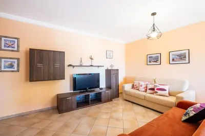 a living room with a couch and a flat screen tv at Milene Guest House in Albufeira