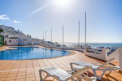 a swimming pool on a balcony with two chairs at Deluxe Flat by Albufeira Holidays in Albufeira
