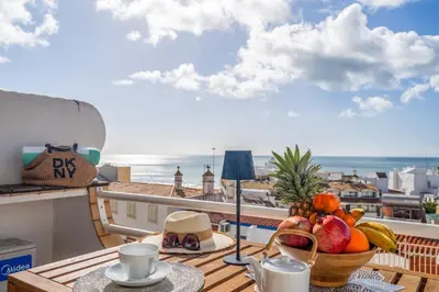 a table with a bowl of fruit on a balcony at Deluxe Flat by Albufeira Holidays in Albufeira