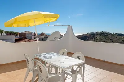 a table and chairs with a yellow umbrella on a balcony at Albufeira Marina Villa by Umbral in Albufeira