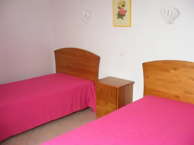 two beds with pink sheets in a room at Albufeira Marina Villa by Umbral in Albufeira
