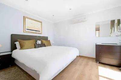 a white bedroom with a large bed and a dresser at Stunning 3 bed Villa in Vale do Lobo with Resort Membership 3 mins From Beach and Golf in Loulé