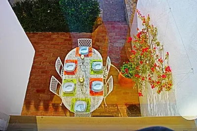 a reflection of a table in a window with flowers at Stunning 3 bed Villa in Vale do Lobo with Resort Membership 3 mins From Beach and Golf in Loulé