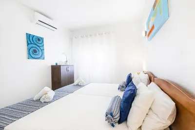 a bedroom with a bed with blue and white pillows at Apartment Venice by Algarve Vacation in Albufeira