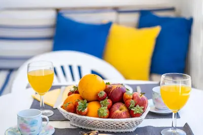 a basket of fruit on a table with two glasses of orange juice at Apartment Venice by Algarve Vacation in Albufeira