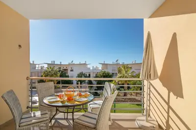 a balcony with a table and chairs and a view at Apartamento da Ourada Marina luz in Albufeira