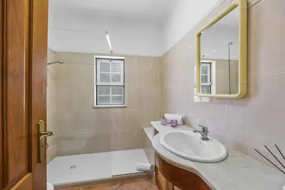 a bathroom with a sink and a shower and a mirror at Villa Casa do Barrocal by Villa Plus in Loulé