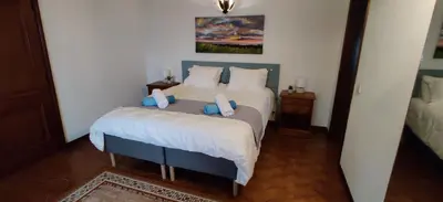 a bedroom with a bed with blue and white sheets at Casal dos Machados - Vista Mar in Benfarras