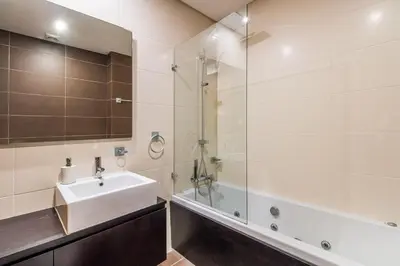a bathroom with a sink and a glass shower at Fantastic Townhouse with Pool and Sea Views in Albufeira