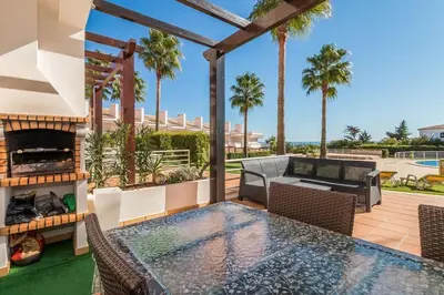 a patio with a table and chairs and a fireplace at Fantastic Townhouse with Pool and Sea Views in Albufeira