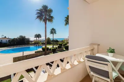 a balcony with a view of a pool and palm trees at Fantastic Townhouse with Pool and Sea Views in Albufeira