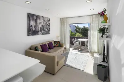 a living room with a couch and a window at Amazing Flat In Olhos de Água in Olhos de Água