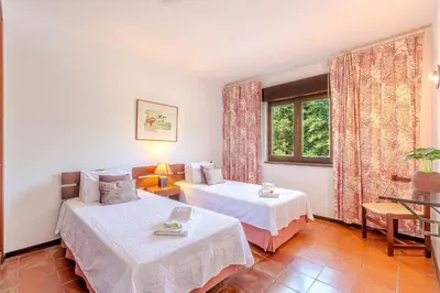 a hotel room with two beds and a window at Apartamento LIMA by Sunnyway in Albufeira
