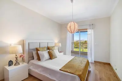 a white bedroom with a large bed and a window at Apartamento Loft 39 by Sunnyway in Albufeira