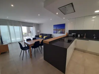 a kitchen and living room with a table and chairs at @Rocking Apartments - Quinta da Alvorada in Albufeira