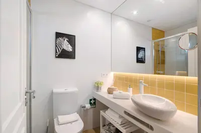 a bathroom with a sink and a toilet and a mirror at África Minha in Vilamoura