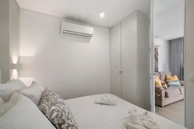 a white bedroom with a bed with towels on it at África Minha in Vilamoura