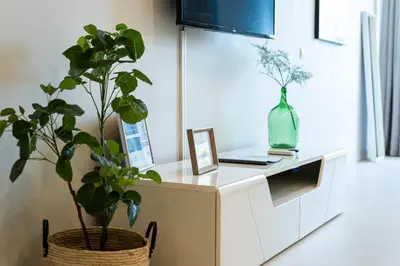 a white cabinet with two potted plants on it at MARC - Vilamoura in Vilamoura