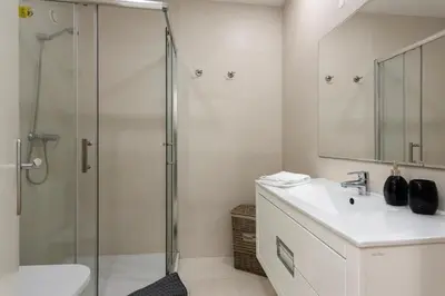 a bathroom with a shower and a sink and a mirror at MARC - Vilamoura in Vilamoura