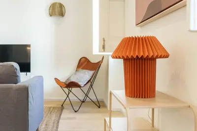 a living room with a trash can and a chair at Modern & Cozy Faro Mercado Apt 11 by Lisbeyond in Faro