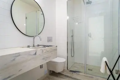 a bathroom with a sink and a shower with a mirror at Modern & Cozy Faro Mercado Apt 11 by Lisbeyond in Faro