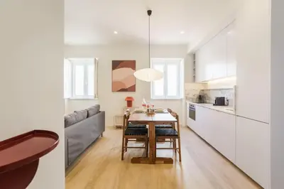 a kitchen and dining room with a table and a couch at Modern & Cozy Faro Mercado Apt 11 by Lisbeyond in Faro