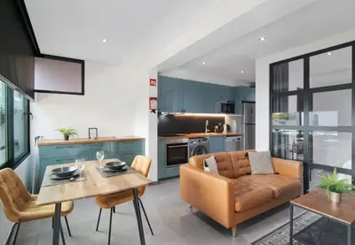 a kitchen and living room with a couch and a table at Cosy Loft in Vilamoura in Vilamoura