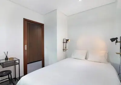 a bedroom with a white bed and a wooden door at Cosy Loft in Vilamoura in Vilamoura