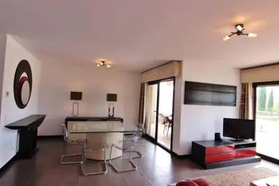 a living room with a glass table and chairs at Monte Laguna Apartment in Quarteira