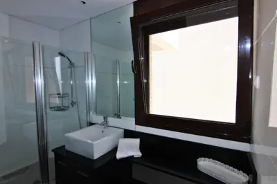 a bathroom with a sink and a glass shower at Monte Laguna Apartment in Quarteira