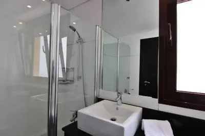 a white bathroom with a sink and a shower at Monte Laguna Apartment in Quarteira