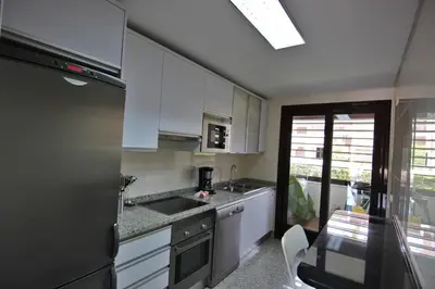 a kitchen with white cabinets and a sink at Monte Laguna Apartment in Quarteira
