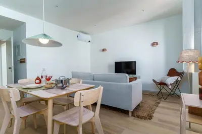 a living room with a table and a couch at Modern & Cozy Faro Mercado Apt 21 by Lisbeyond in Faro