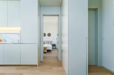 a hallway with white walls and a room with a bed at Modern & Cozy Faro Mercado Apt 21 by Lisbeyond in Faro