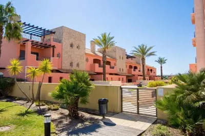 a house with palm trees and a fence at Beautiful Family T3 Townhouse with Pool Vilamoura in Vilamoura
