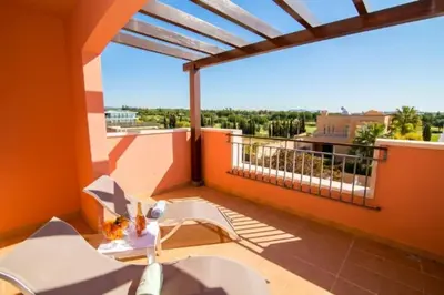 a balcony with orange walls and a table and chairs at Beautiful Family T3 Townhouse with Pool Vilamoura in Vilamoura