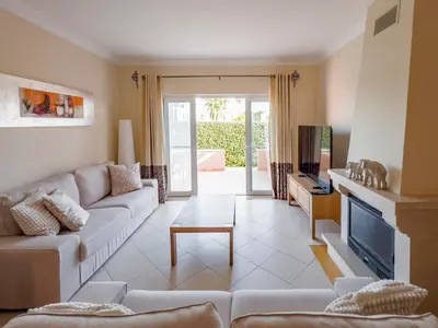 a living room with a couch and a tv at Beautiful Family T3 Townhouse with Pool Vilamoura in Vilamoura