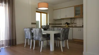 a kitchen with a table and chairs in a room at Vila Atlantida Apartment in Vilamoura