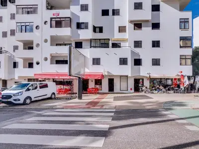 a white van parked in front of a building at AL - Apartamento Quarteira Avenida in Quarteira
