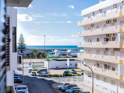 a view from the balcony of a building with a parking lot at AL - Apartamento Quarteira Avenida in Quarteira