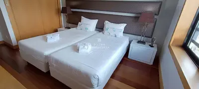 a bedroom with two beds and a desk and a window at Apartamento Panoramico - By Dalma Portuguesa in Albufeira