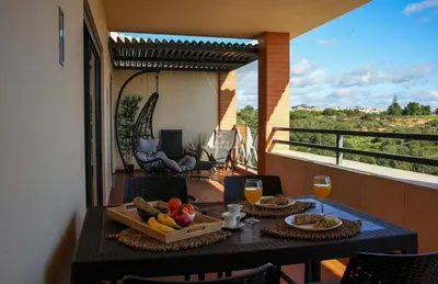a table with a tray of fruit on a balcony at Apartamento Panoramico - By Dalma Portuguesa in Albufeira
