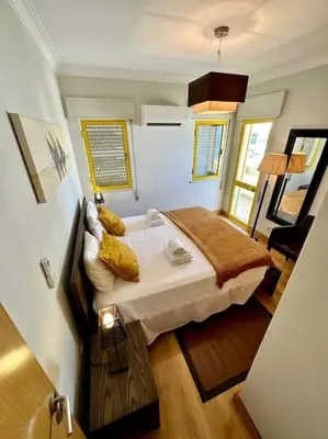 a small bedroom with a bed in a room at TOM's House - T2 Sea View in Quarteira