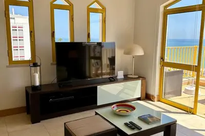 a living room with a television and a table at TOM's House - T2 Sea View in Quarteira